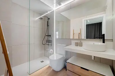 a bathroom with a toilet and a sink and a shower at Hauzify I Apartaments Voramar in San Pol de Mar