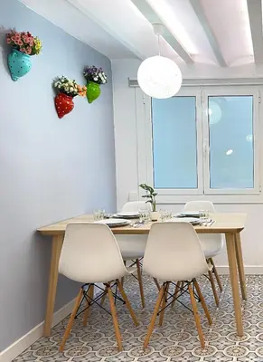 a dining room with a wooden table and white chairs at Lazy Donkey Sagrada Familia in Barcelona