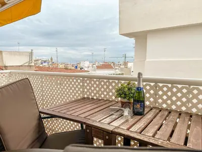 a wooden table with a bottle of wine on a balcony at Sira House by Hello Homes Sitges in Sitges
