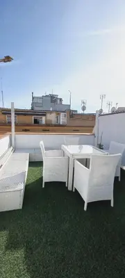 a patio with a table and chairs on a roof at Casa dess in Hospitalet de Llobregat