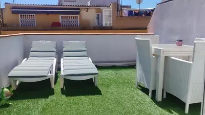 a table and chairs on a patio with grass at Casa dess in Hospitalet de Llobregat