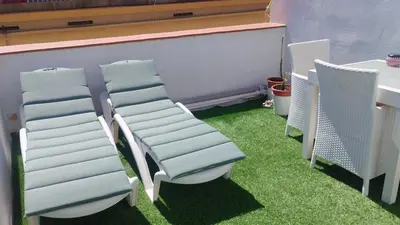 a group of chairs sitting on grass next to a table at Casa dess in Hospitalet de Llobregat