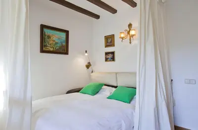 a bedroom with a white bed with green pillows at Apartment Eixample Comfort in Barcelona