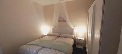 a small bedroom with a bed with a canopy at Cozy and sunny penthouse Fira BCN in Hospitalet de Llobregat