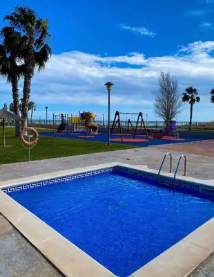 a swimming pool in a park with a playground at Playa, piscina, parking GENIAL in Cubelles