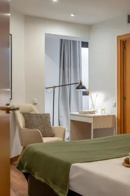 a bedroom with a bed and a chair and a desk at Canela Homes BARCELONA FLORIDABLANCA in Barcelona