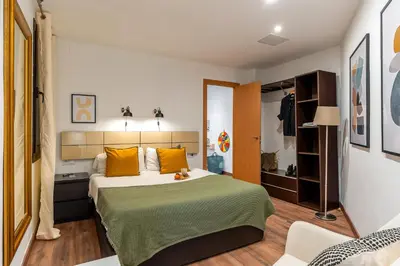 a bedroom with a large bed with yellow pillows at Canela Homes BARCELONA FLORIDABLANCA in Barcelona
