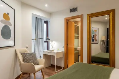 a bedroom with a bed and a desk and a chair at Canela Homes BARCELONA FLORIDABLANCA in Barcelona
