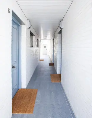 a hallway with white walls and a blue door at Durlet Rambla Mar Apartments in Barcelona