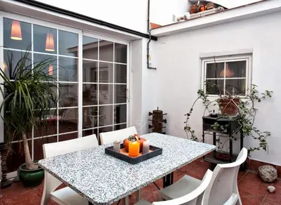 a table and chairs on a patio with a table and a window at Holiday home La casa azul in Barcelona