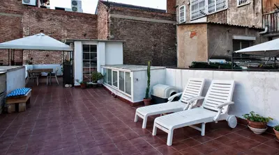a patio with two chairs and a table and umbrella at Holiday home La casa azul in Barcelona