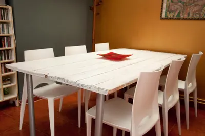 a white table with white chairs and a red leaf on it at Holiday home La casa azul in Barcelona