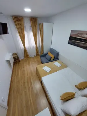 a small room with two beds and a couch at MI CASA ES TU CASA in Hospitalet de Llobregat