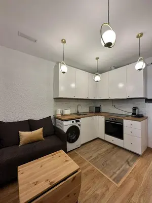 a living room with a couch and a kitchen at MI CASA ES TU CASA in Hospitalet de Llobregat