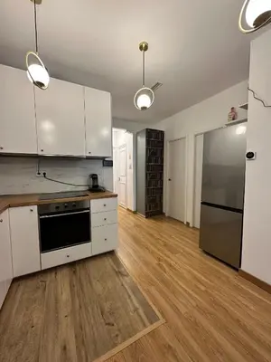 an empty kitchen with white cabinets and a refrigerator at MI CASA ES TU CASA in Hospitalet de Llobregat