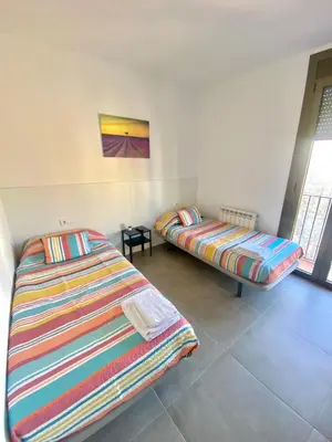 a room with two beds in a room at Hostal La Masia in Manresa