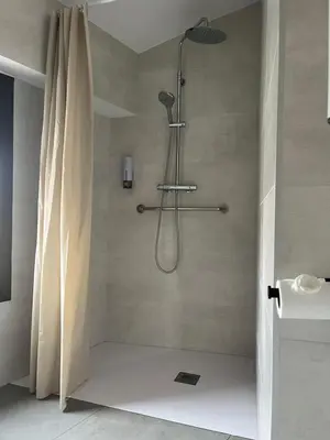 a shower with a shower curtain in a bathroom at Hostal La Masia in Manresa