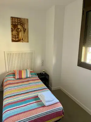 a bedroom with a bed with a striped blanket at Hostal La Masia in Manresa