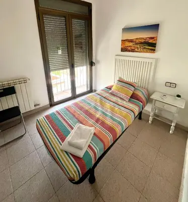 a bed in a room with a window at Hostal La Masia in Manresa