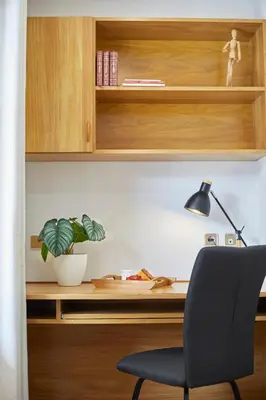 a desk with a chair and a potted plant at BBarcelona Gràcia Nova Flat in Barcelona