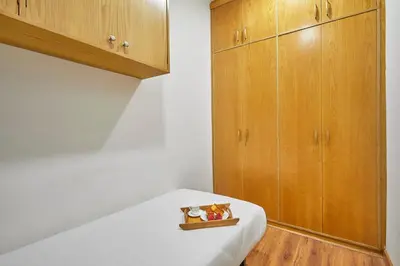 a room with wooden cabinets and a table with a white table sidx sidx at BBarcelona Gràcia Nova Flat in Barcelona