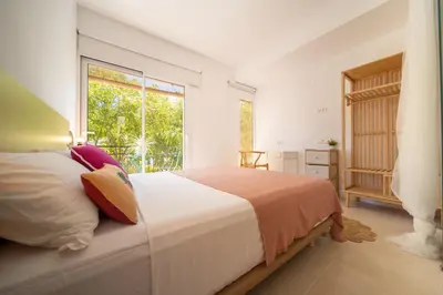 a bedroom with a bed and a large window at Sitges Beach Hostal in Sitges