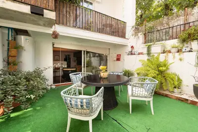 a living room with a couch and chairs and a table at Sitges Beach Hostal in Sitges