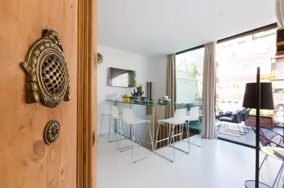 a kitchen and living room with a table and chairs at En Ville Boutique Apartments Sant Antoni in Barcelona