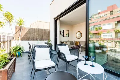 a patio with chairs and tables on a balcony at En Ville Boutique Apartments Sant Antoni in Barcelona
