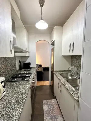 a kitchen with white cabinets and a sink and a stove at Apartment carrer d'Olesa in Barcelona