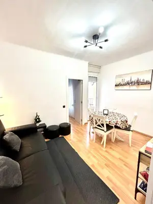 a living room with a black couch and a table at Apartment carrer d'Olesa in Barcelona