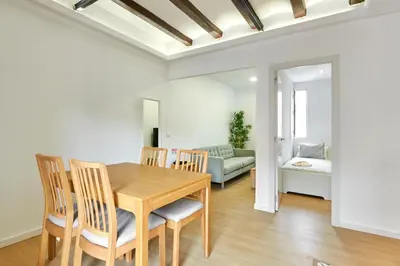 a dining room with a table and chairs and a couch at Ma Bright apartment next to Parc de Montjuïc in Barcelona