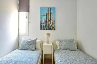 a bedroom with two beds and a picture on the wall at Ma Bright apartment next to Parc de Montjuïc in Barcelona