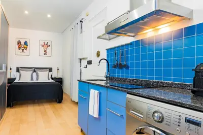 a blue and white kitchen with a bed in the background at R&B Mila in Barcelona