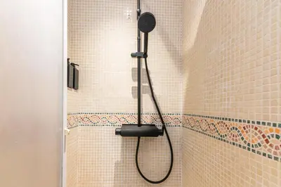 a shower with a shower head in a bathroom at R&B Mila in Barcelona