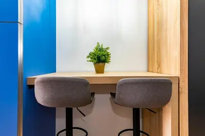 a desk with two chairs and a plant on it at R&B Mila in Barcelona