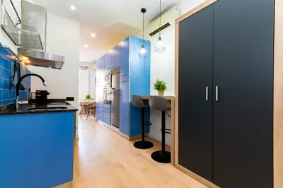 a kitchen with blue walls and a sliding door at R&B Mila in Barcelona