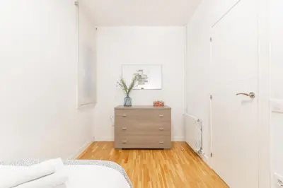 a bedroom with a dresser in a white room at Elegance Barcelona Rentals in Barcelona