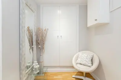 a white room with a white chair and a mirror at Elegance Barcelona Rentals in Barcelona
