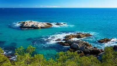 a view of the ocean with rocks in the water at Swiss style villa near Barcelona 10min to beach in Sant Cebrià de Vallalta