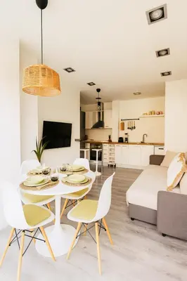 a living room and kitchen with a table and chairs at Apartamento Sol Terraza in Montgat
