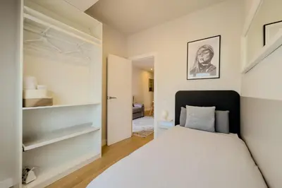 a bedroom with a white bed and shelves at Barcelona Amelie Apartment in Hospitalet de Llobregat
