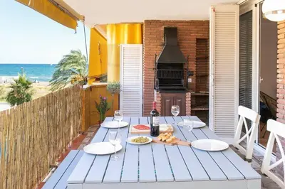 a table with plates of food and a bottle of wine at Canela Homes COSTA CALMA in Castelldefels