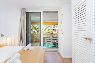 a bedroom with a bed and a view of a patio at Canela Homes COSTA CALMA in Castelldefels