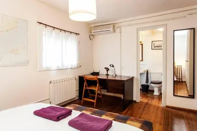 a bedroom with a desk and a bed with purple pillows at Canela Homes BARCELONA BORN in Barcelona