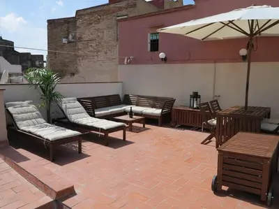 a patio with a bunch of chairs and an umbrella at Canela Homes BARCELONA BORN in Barcelona