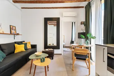 a living room with a black couch and chairs at Lodging Apartments Almirall Beach 41 in Barcelona