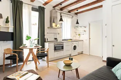 a living room with a couch and a kitchen at Lodging Apartments Almirall Beach 41 in Barcelona