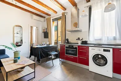 a kitchen with red cabinets and a washer at Lodging Apartments Almirall Beach 51 in Barcelona