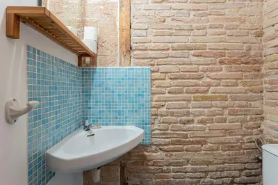 a bathroom with a sink and a brick wall at Canela Homes BARCELONA JOVELLANOS in Barcelona